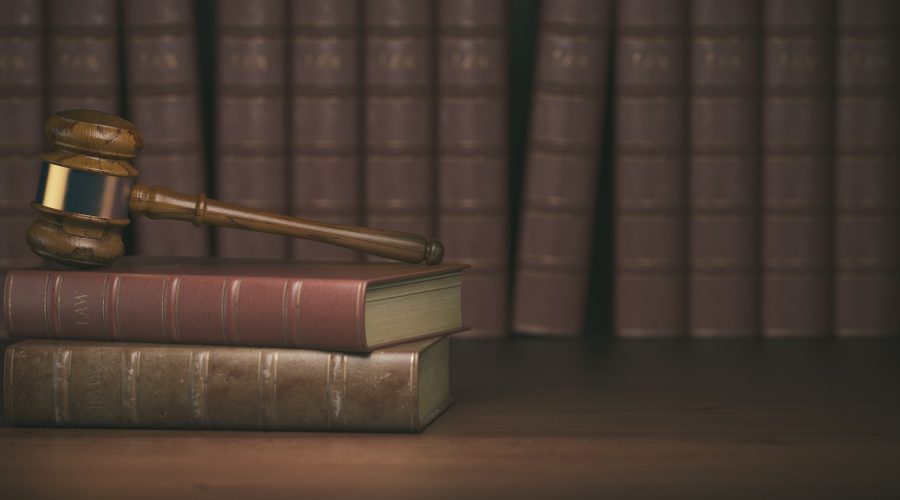 Gavel on the background of vintage lawyer books. Concept of law